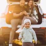 Famille arretee en bord de route pendant un long trajet en voiture avec un bebe